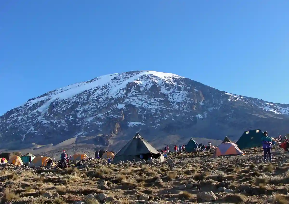 Experienced guides for Kilimanjaro rest in tents at the summit, overlooking the vast landscape.