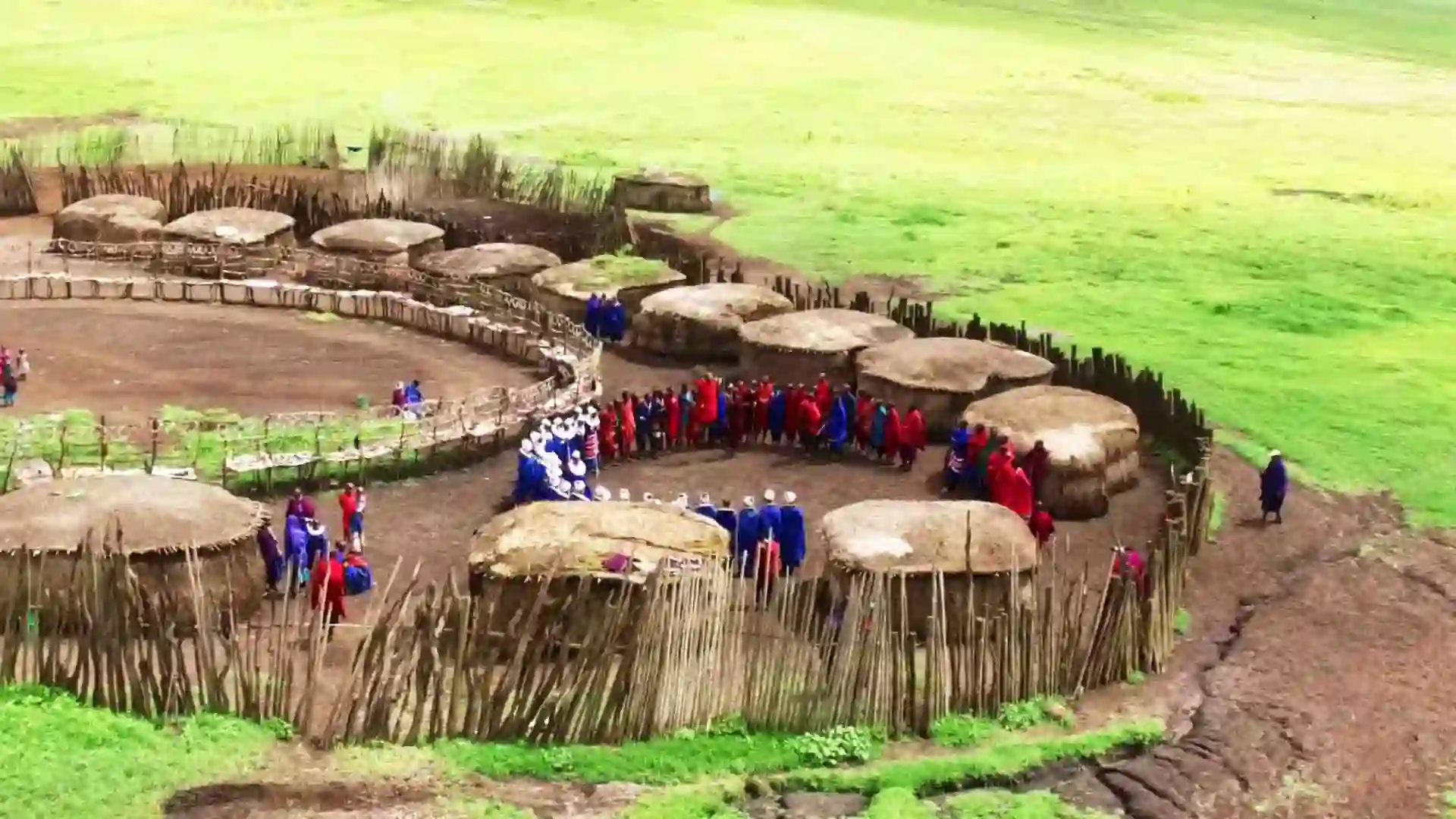 A group of Maasai people gather outside their traditional boma in Arusha, Tanzania, offering a unique cultural tours travel advice experience.