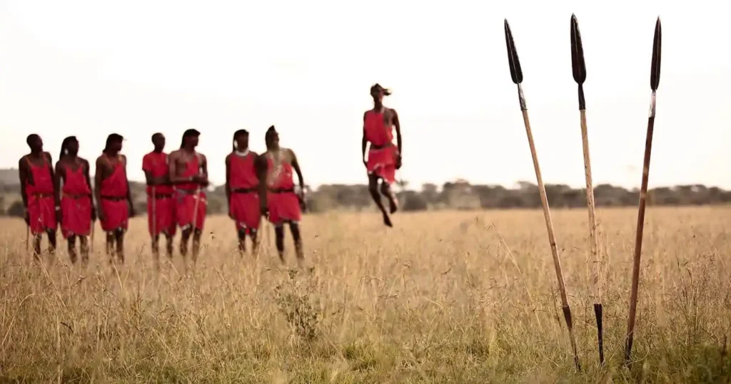 A group of people adorned in vibrant traditional Maasai attire engaging in cultural activities in a Maasai village, representing the essence of Maasai culture.