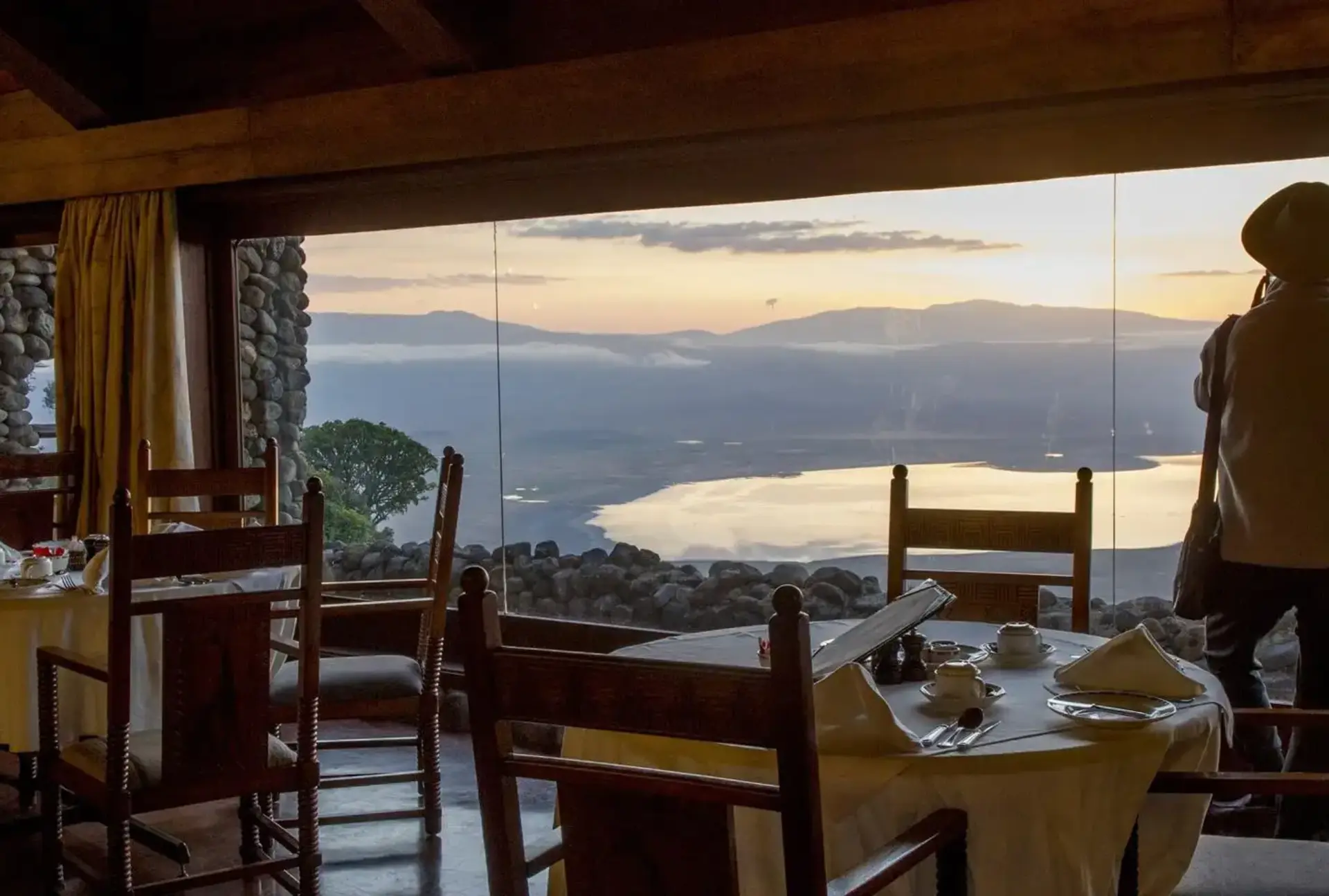 Majestic Encounter: African Safaris - Lion in Tanzania's Wilderness A breathtaking view from the dining area of Ngorongoro Serena Safari Lodge Accommodation, overlooking the vast savannah landscape.