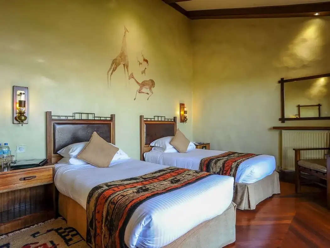 Majestic Encounter: African Safaris - Lion in Tanzania's Wilderness Standard room at Serena Ngorongoro Crater Lodge accommodation, featuring cozy furnishings and warm ambiance