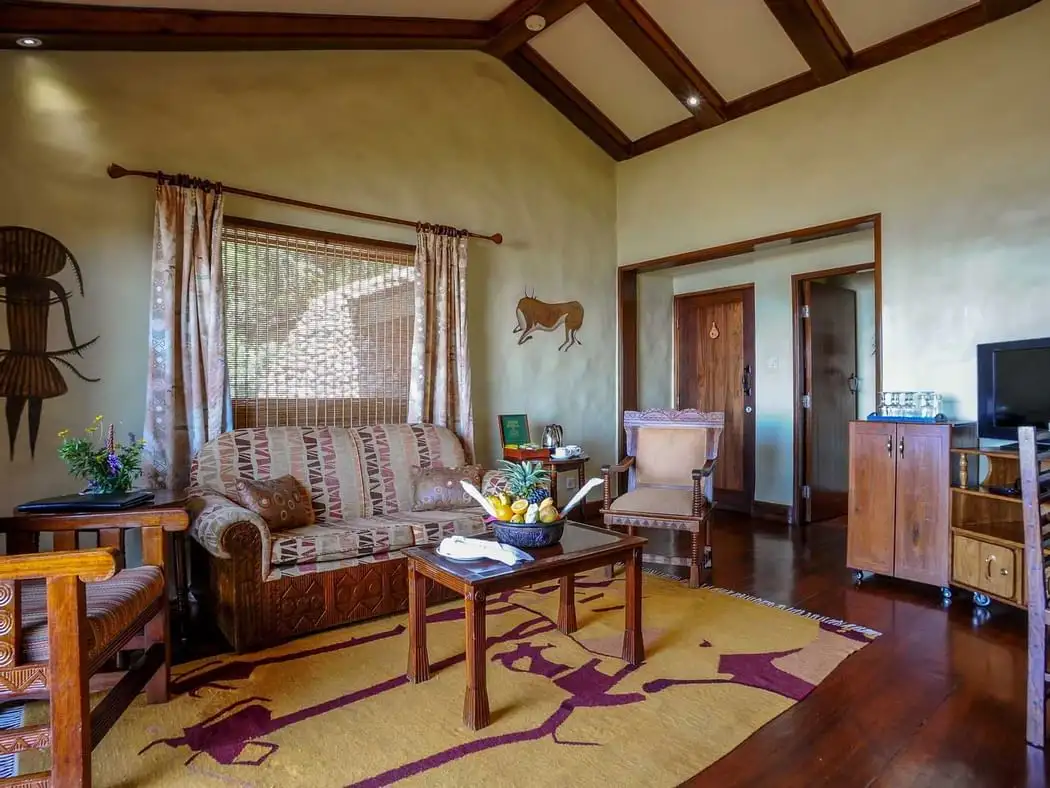 Majestic Encounter: African Safaris - Lion in Tanzania's Wilderness Enjoy exquisite Ngorongoro Serena Lodge accommodation in the serene ambiance of the Kimba Suite, blending luxury with nature's beauty.