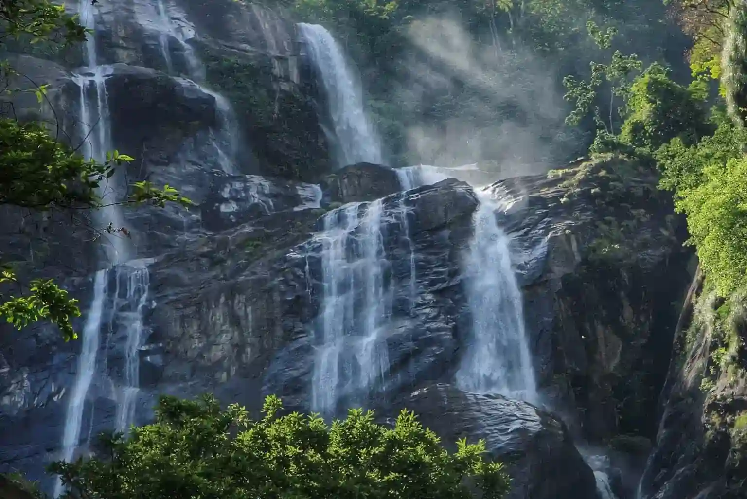 Cascading waterfalls amidst lush greenery, a must-see in the Gombe National Park Travel Guide.