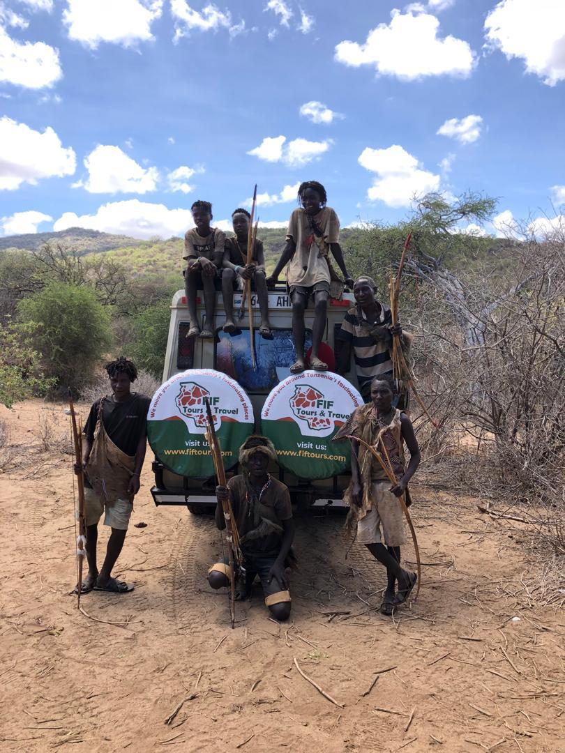 A group of safari adventurers observing a pride of lions in their natural habitat during a Tanzania Safari Trip.