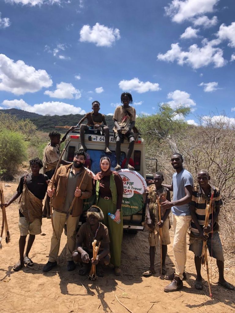 A group of travelers interacting with members of the Adzabe Tribes in Tanzania during Tanzania Cultural Tours.